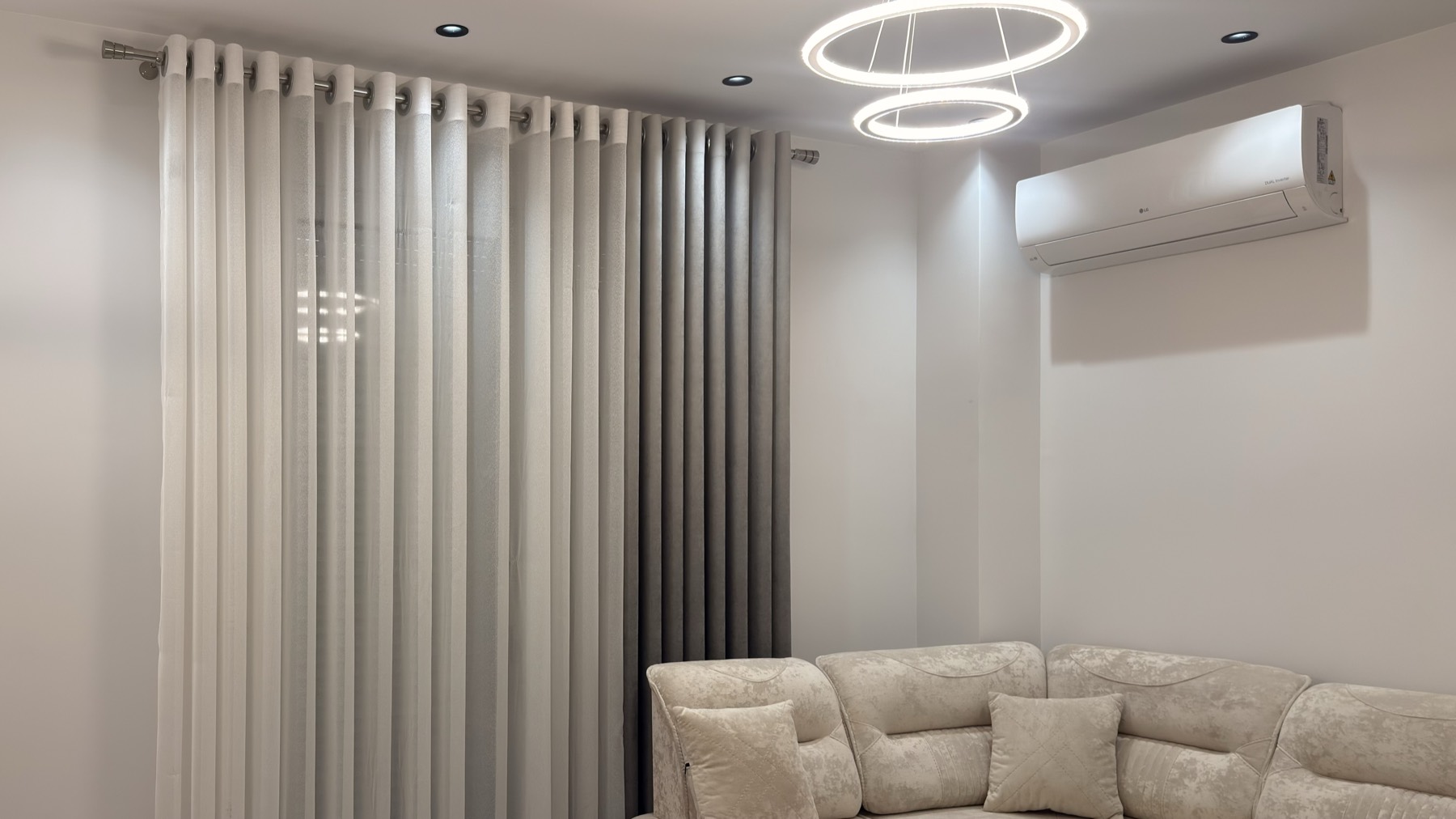 Plush lounge corner with layered curtains and soft light